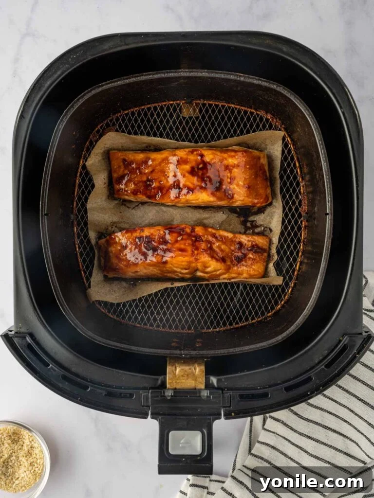 Crispy and glazed air-fried salmon fillets beautifully cooked in an air fryer basket.