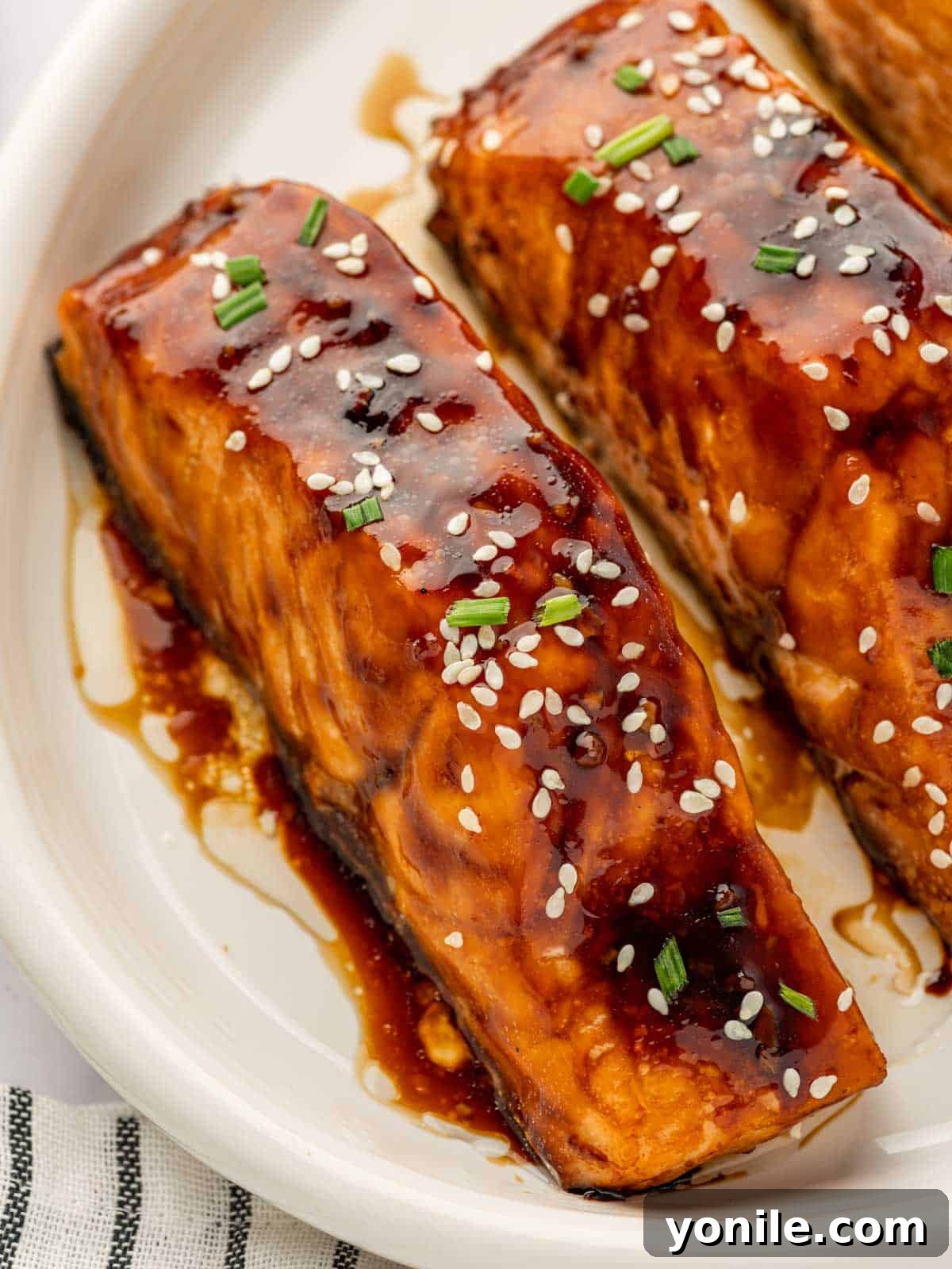 A close-up shot of a succulent air-fried teriyaki salmon fillet, showcasing its perfectly glazed, caramelized surface and tender flakes.