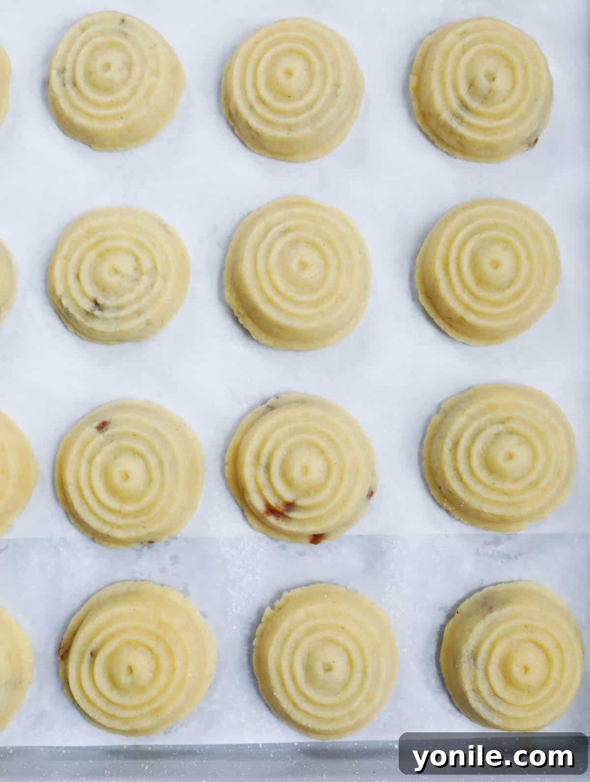 Maamoul Irresistible Date Cookies 11 Maamoul date cookies neatly arranged on a sheet pan, ready for baking.