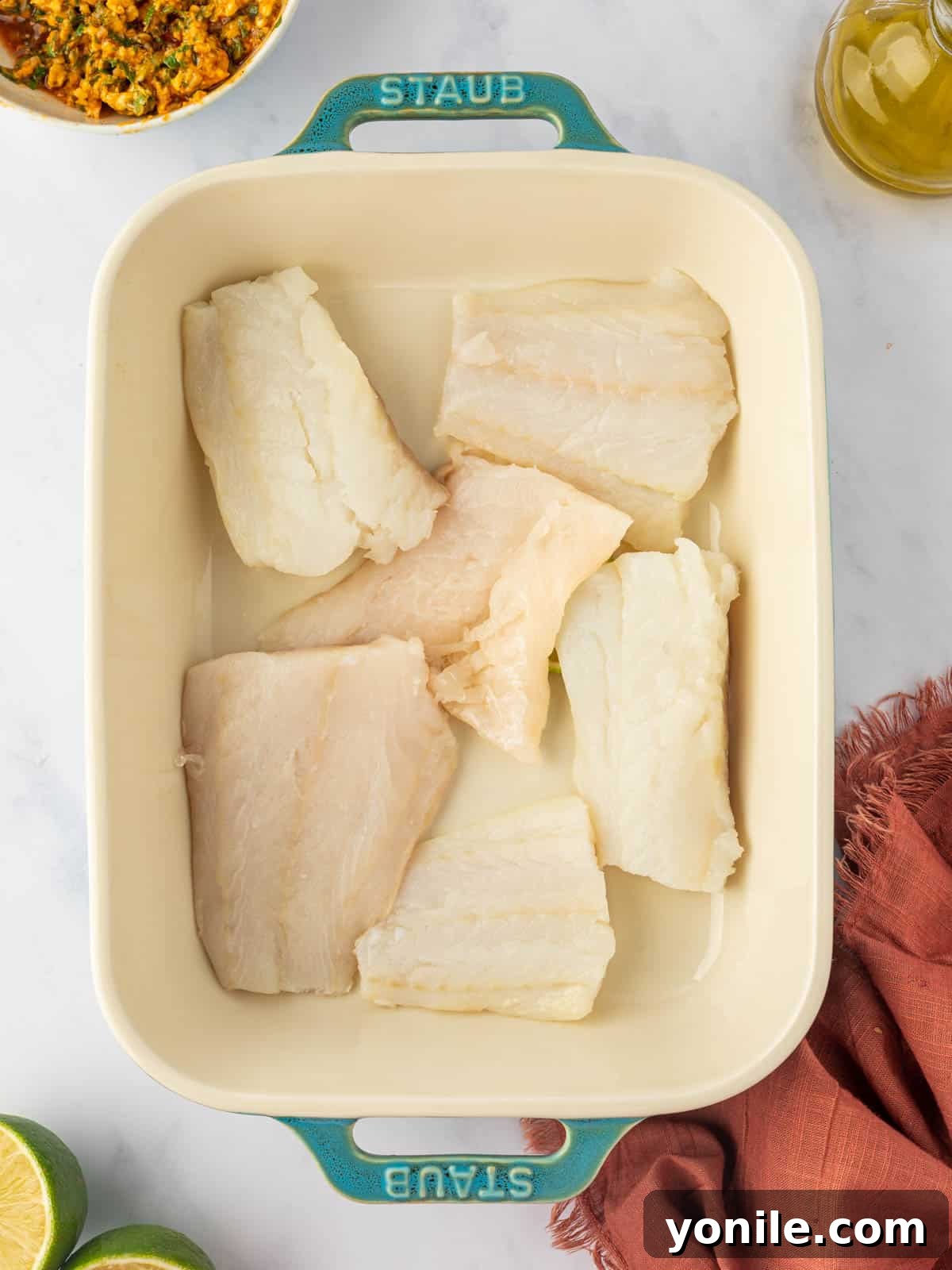 Savory Herb Crusted Cod Bake 4 Dry cod fillets placed neatly in a baking dish, ready for seasoning.