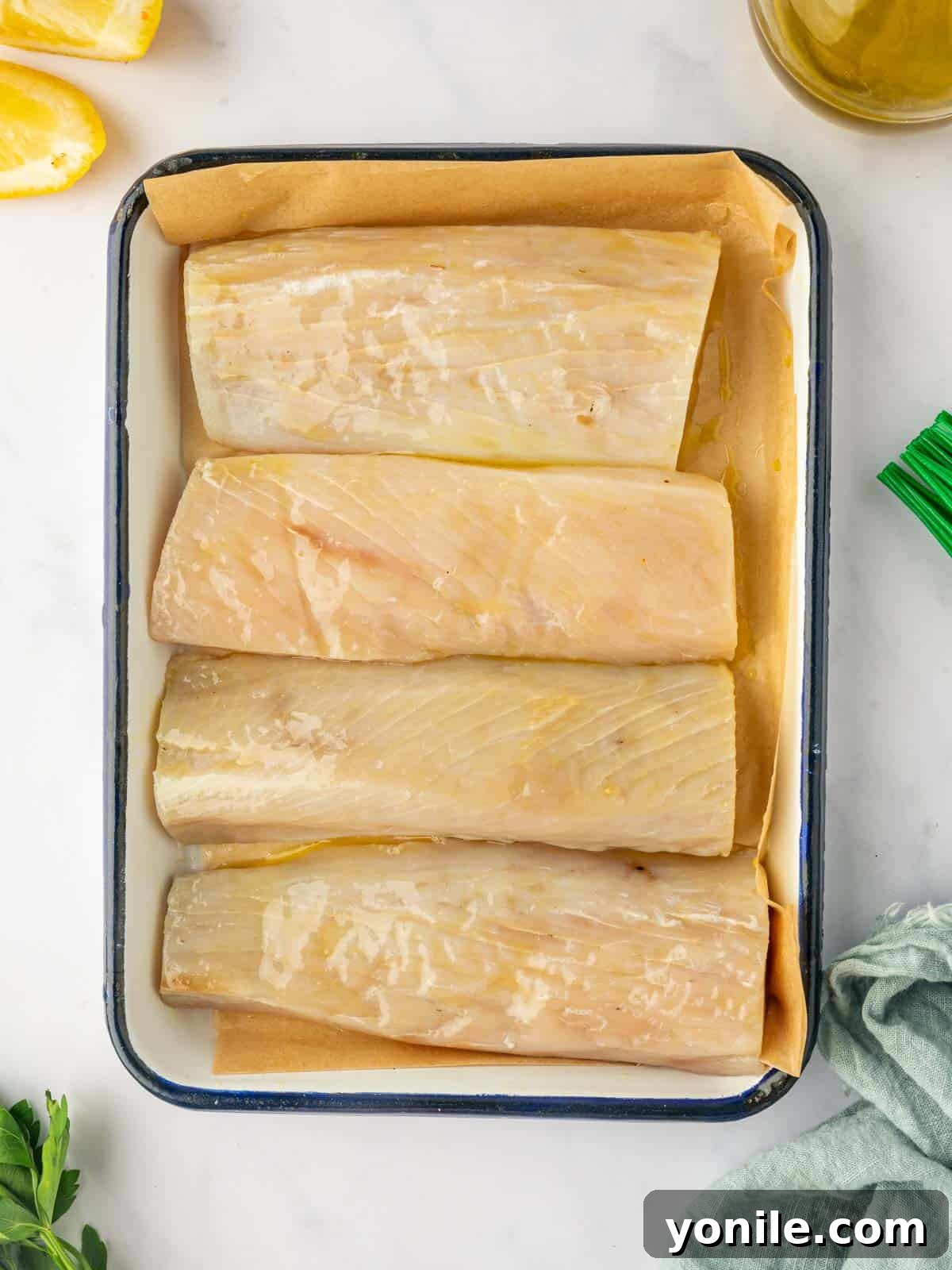 A raw Mahi Mahi fish fillet rests on a pan, prepared for seasoning and cooking.