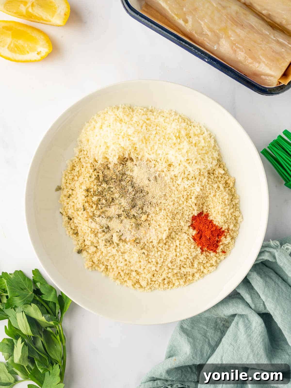 A bowl filled with a mixture of panko breadcrumbs and various spices, ready for breading the fish.