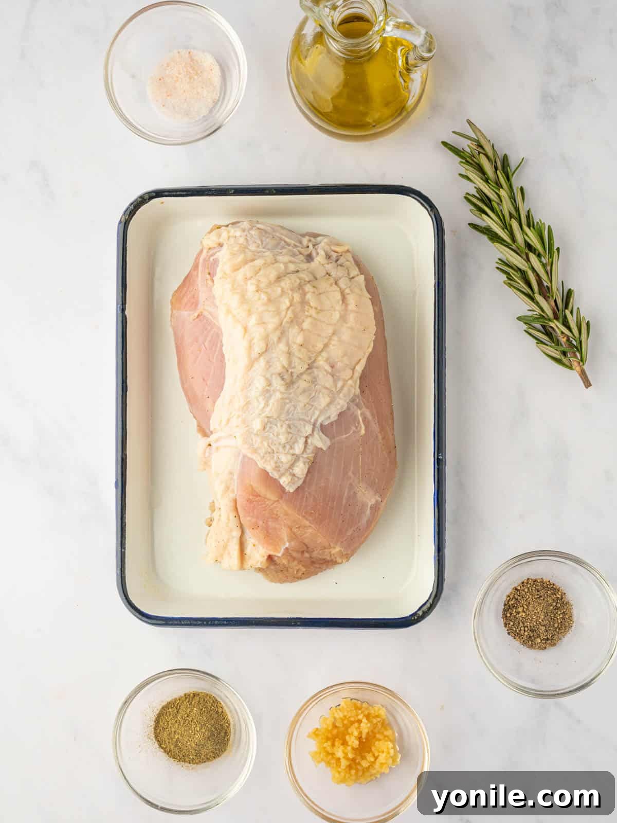 Various ingredients, including turkey breast, olive oil, garlic, and an assortment of spices, laid out on a kitchen counter, ready for preparing air fryer turkey breast.