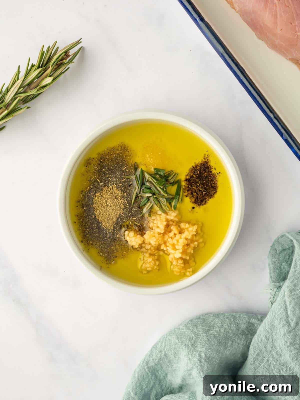 Olive oil and various spices are mixed in a bowl, creating a rich seasoning blend for the turkey breast.