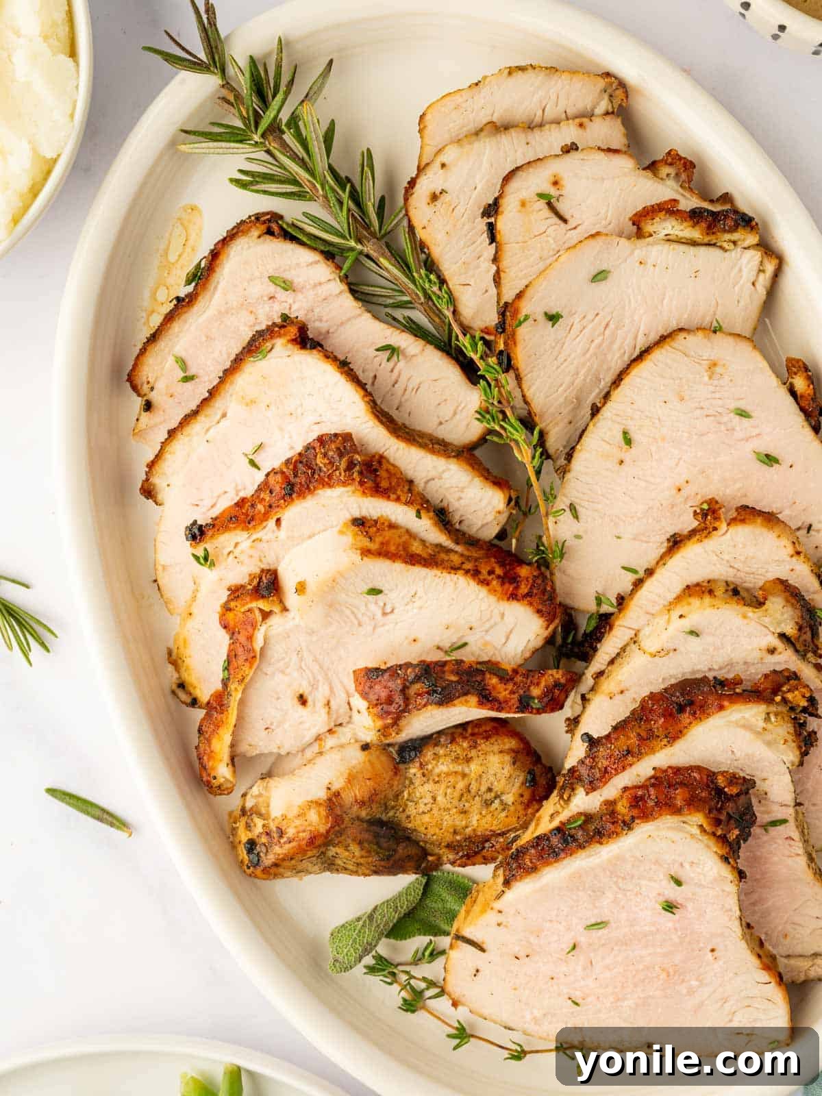 Perfectly sliced turkey breast arranged neatly on a platter, showcasing its juicy texture and golden crust.