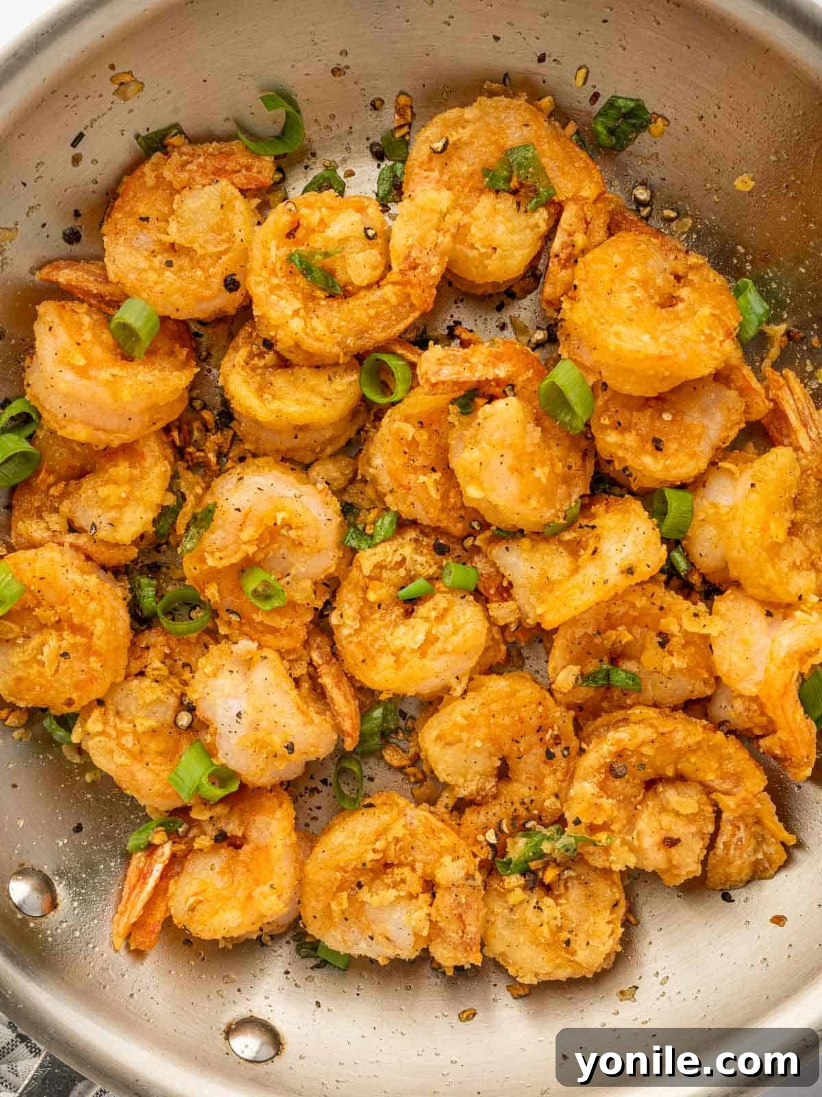 Close-up of crispy Chinese salt and pepper shrimp, showcasing the golden coating and seasoning.