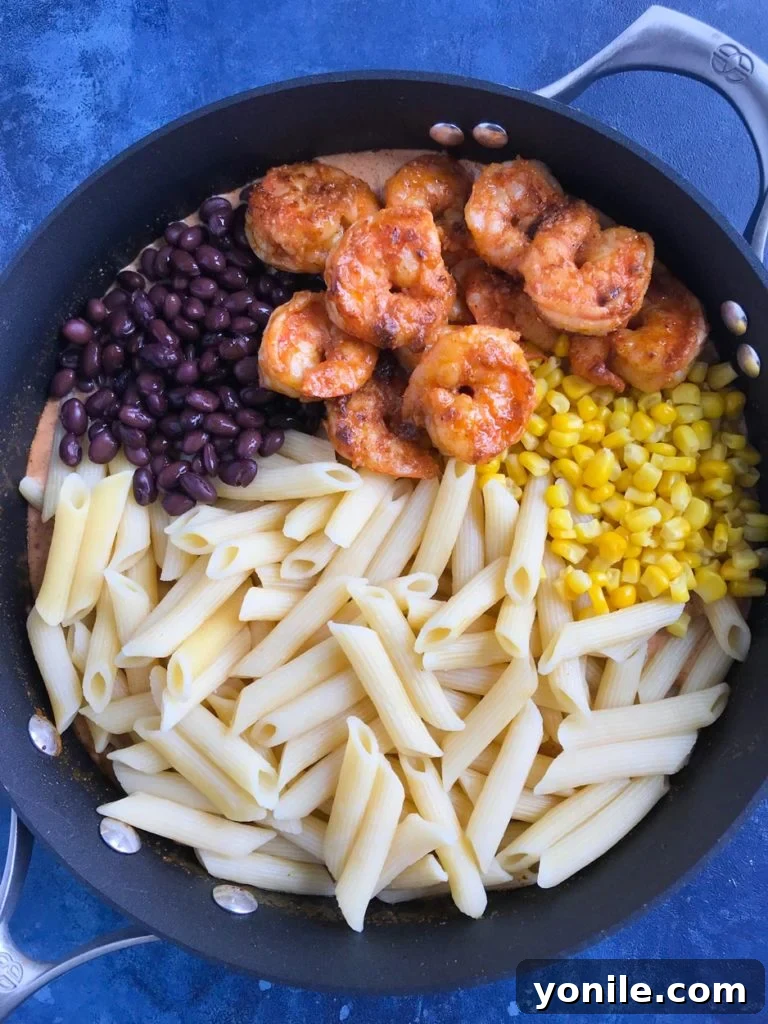 Fiesta Creamy Shrimp Pasta 5 Creamy Southwest Shrimp Pasta mixing pasta, shrimp, corn, and black beans