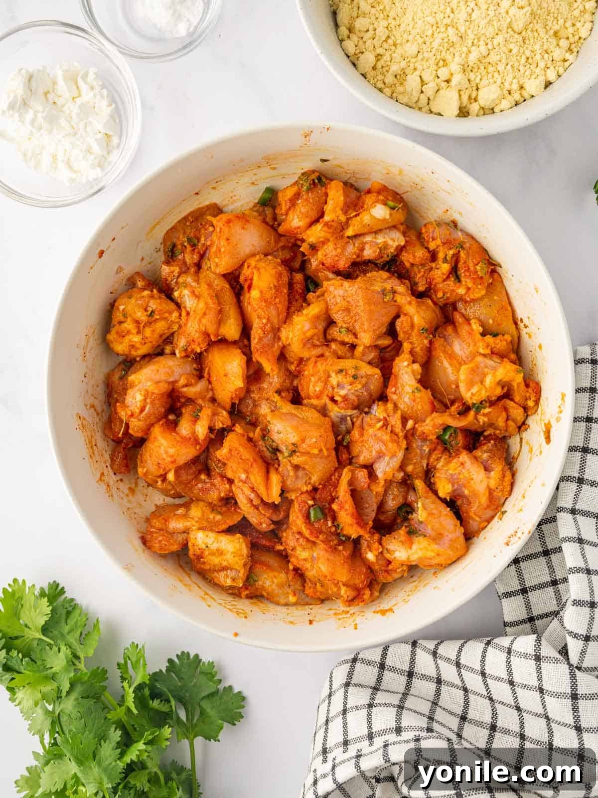 Bite-sized chicken cubes thoroughly marinated in a rich, spicy seasoning blend, ready for the next step.