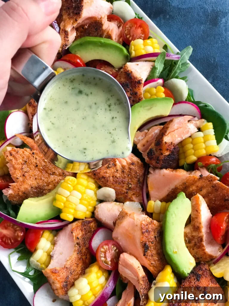 A close-up of spicy salmon salad with a generous drizzle of homemade dressing.