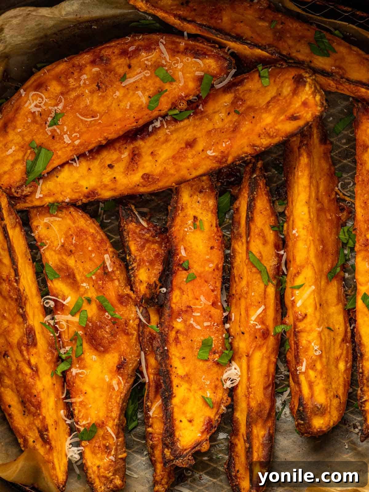 A close-up of perfectly crispy sweet potato wedges arranged on a serving platter, highlighting their golden-brown color and inviting texture.