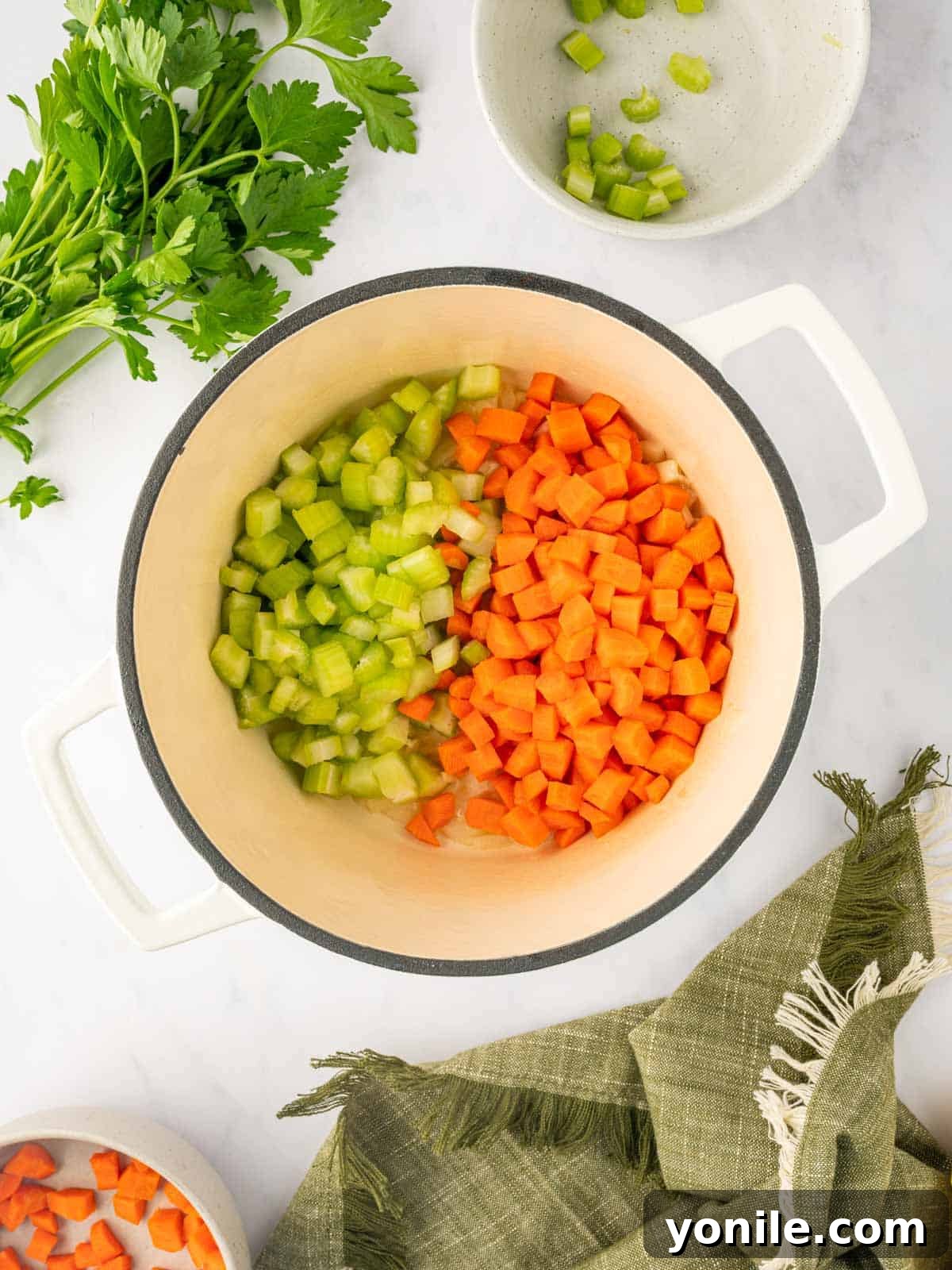 Celery and carrots are cooked in a dutch oven.