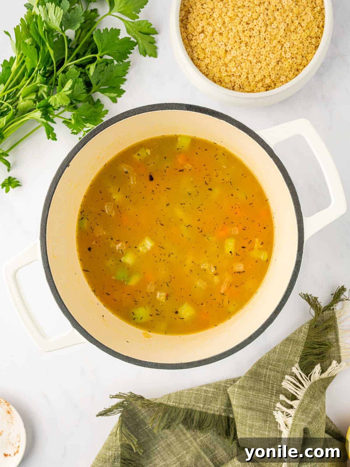 Broth and vegetables are cooked in a dutch oven.