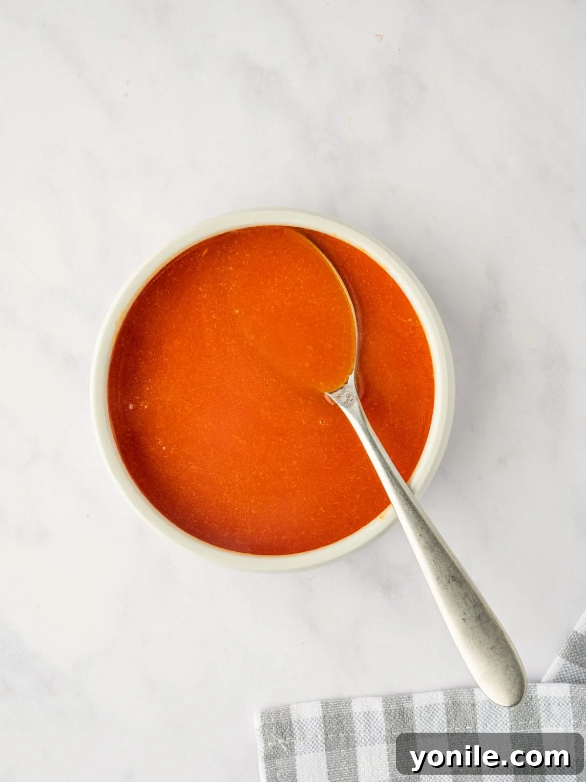 Freshly mixed homemade buffalo sauce in a small ceramic bowl.