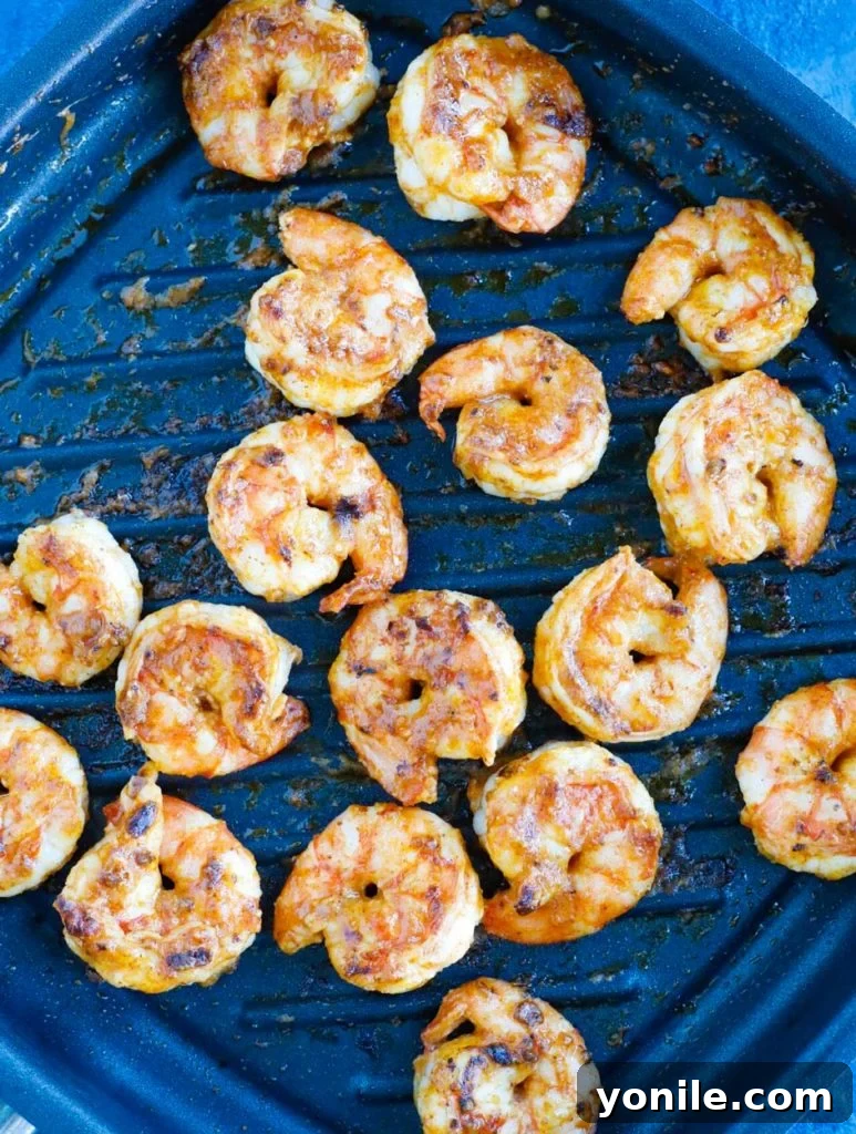 Zesty Shrimp Taco Meal Planning 2 Close-up of seasoned raw shrimp in a grill pan, ready to be cooked to perfection for a shrimp taco meal prep.