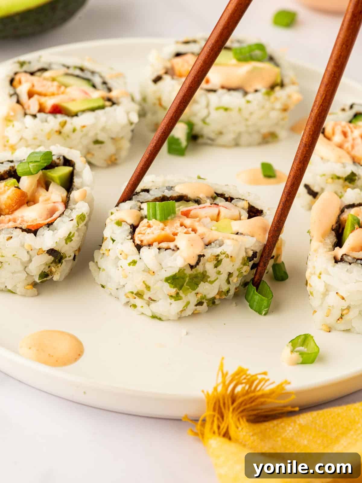 Dynamite Salmon Roll 16 A pair of chopsticks elegantly picks up a piece of spicy salmon sushi.