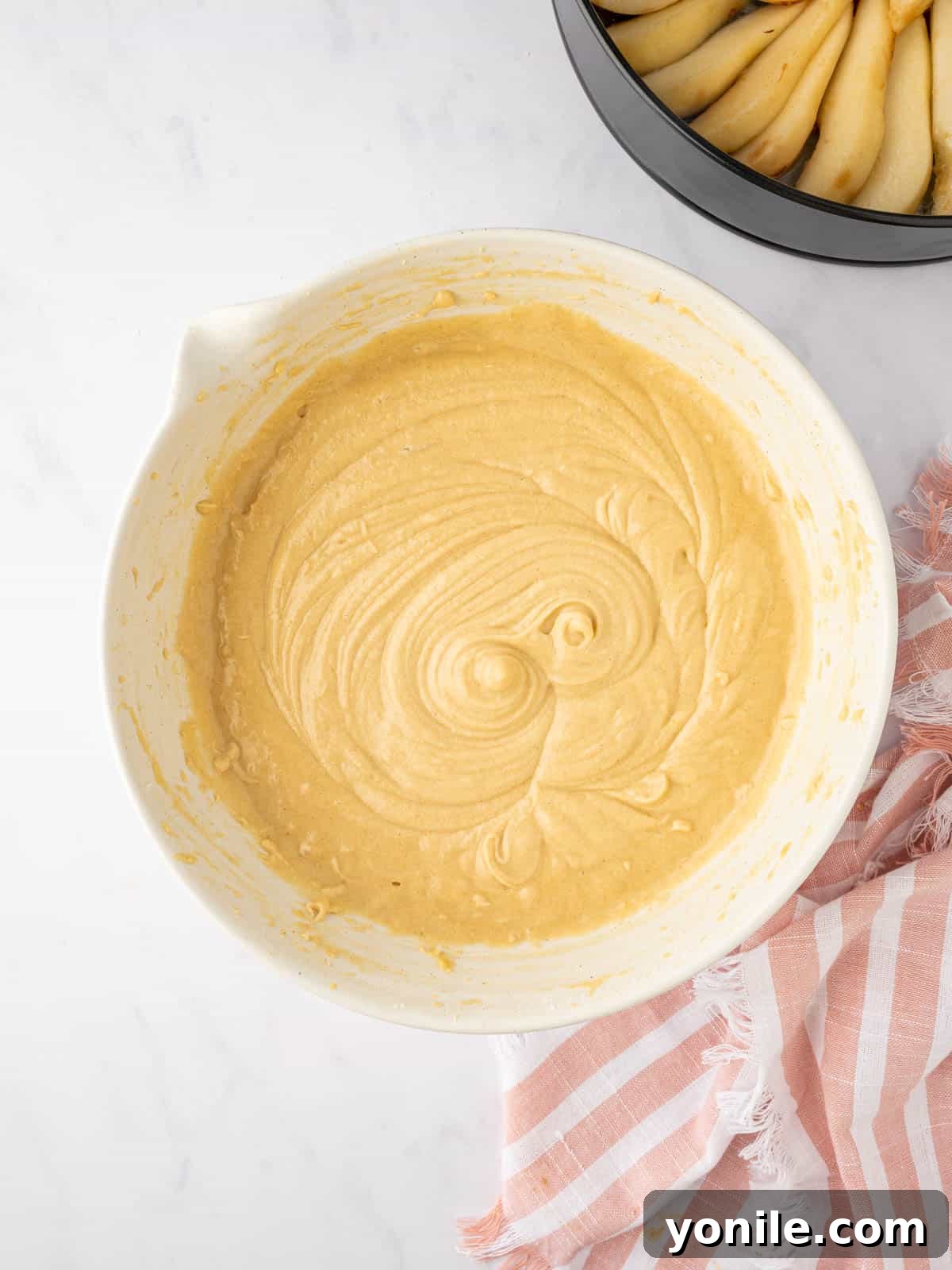 A bowl of fully prepared cake batter, smooth and ready for the pan.
