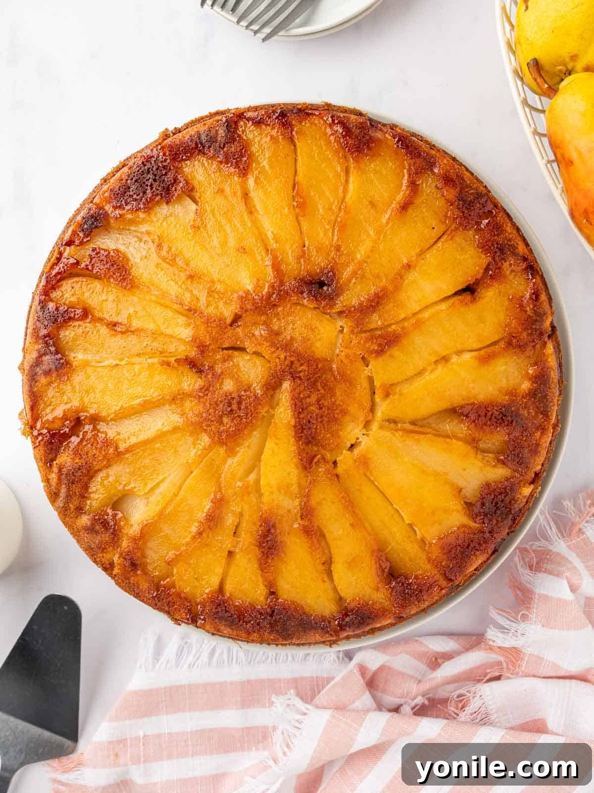 A whole upside down pear cake beautifully presented on a platter.