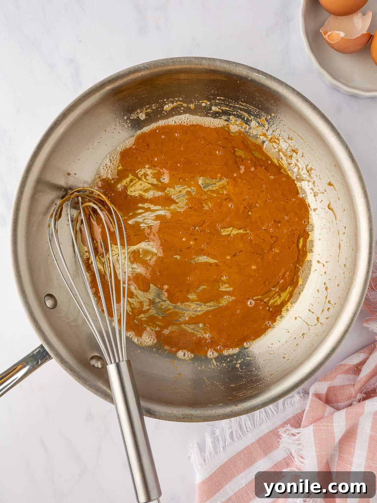 Golden-brown caramel sauce simmering in a skillet.