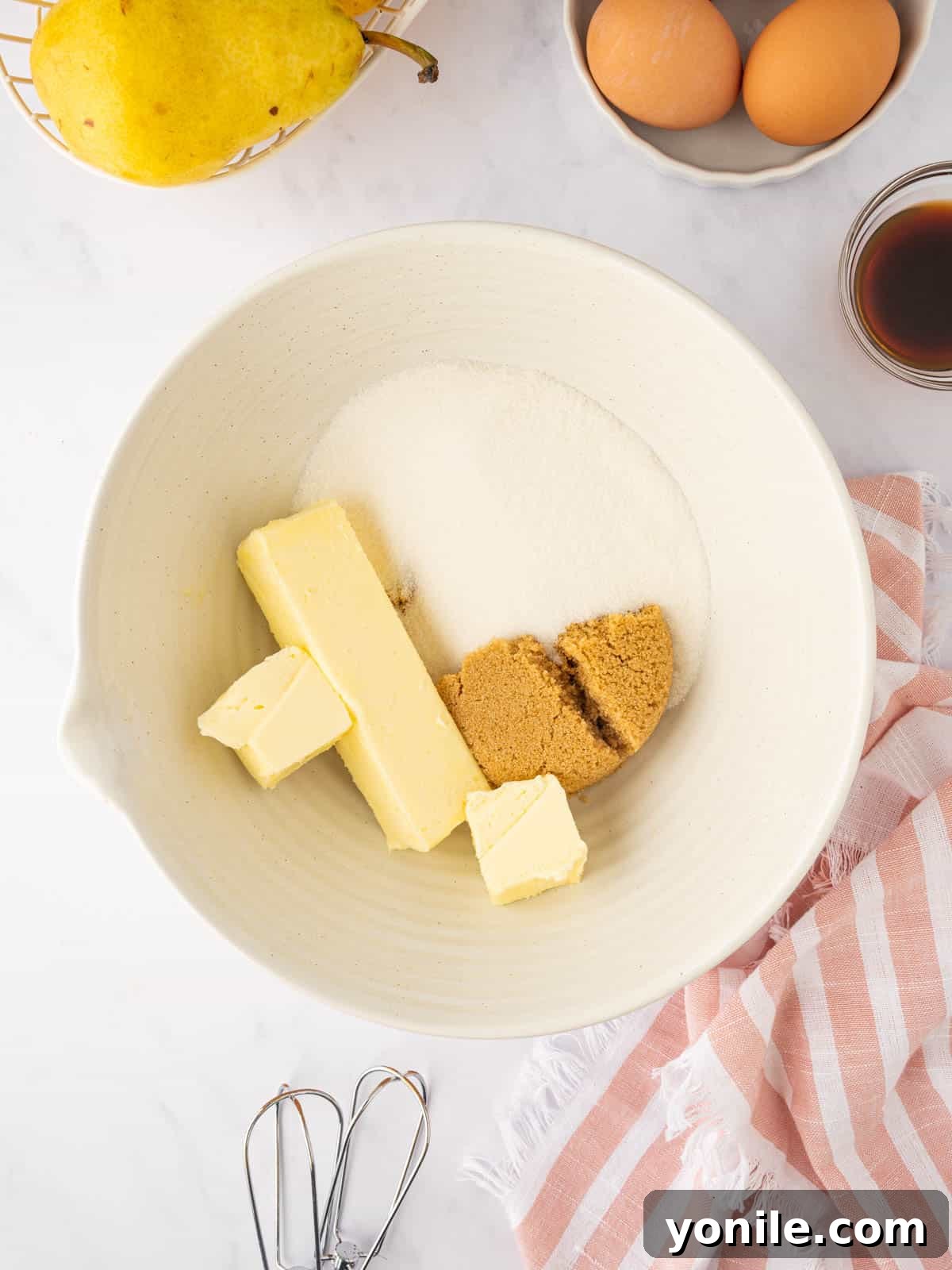 Softened butter and sugars are creamed together in a bowl with a hand mixer.
