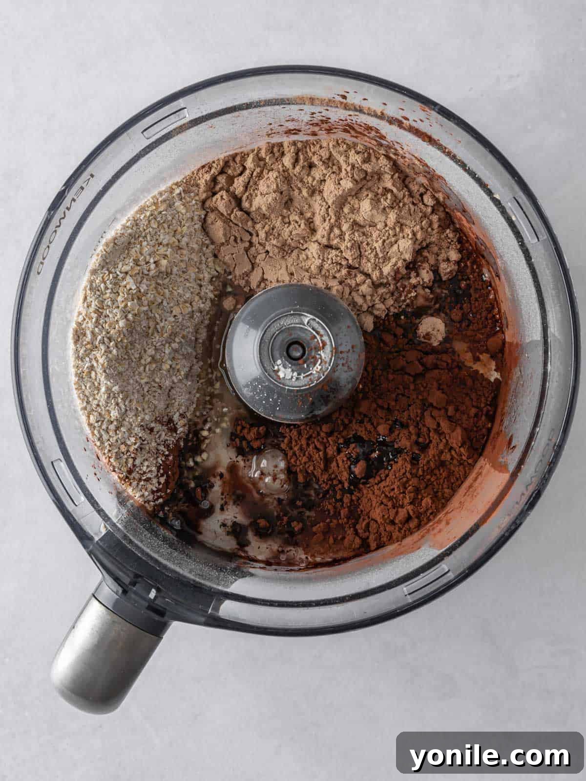 All pancake ingredients fully mixed into a smooth, thick batter in a food processor bowl.