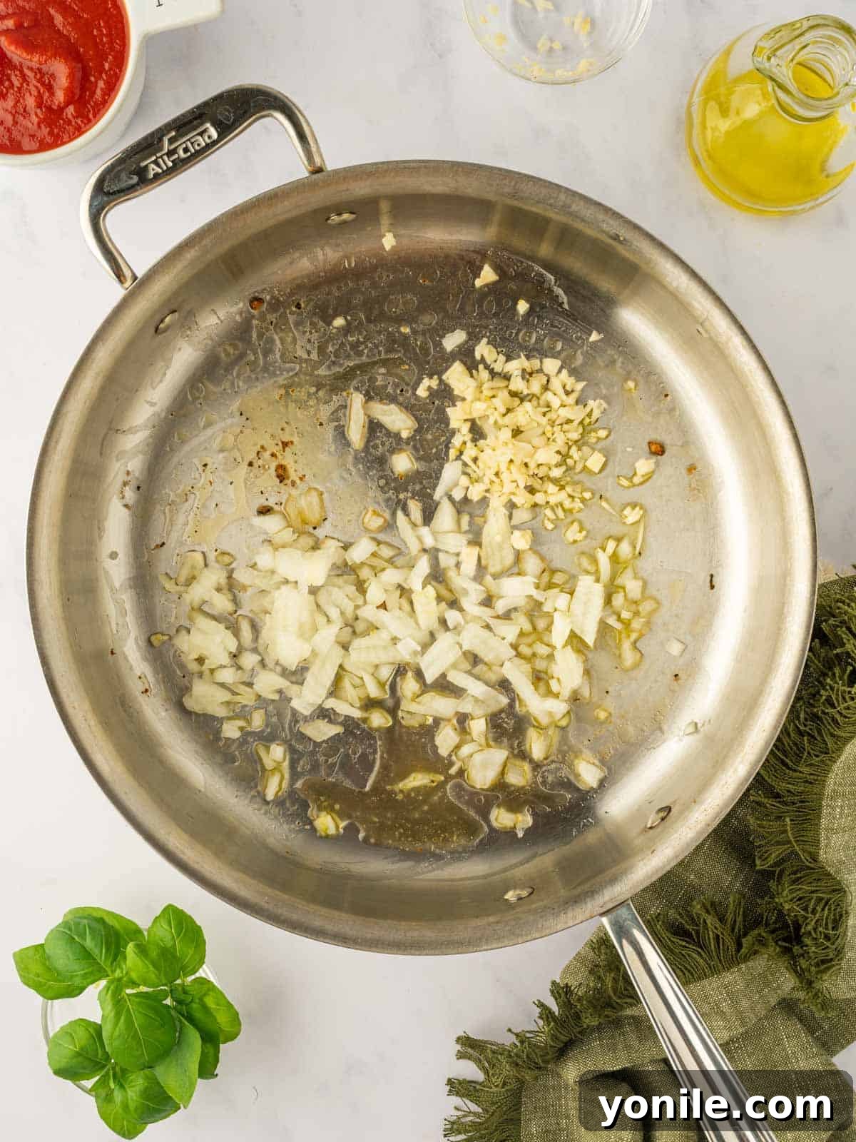 Prawn Pasta Perfection 6 Chopped garlic and onions sizzling in a skillet, creating an aromatic base for the sauce.