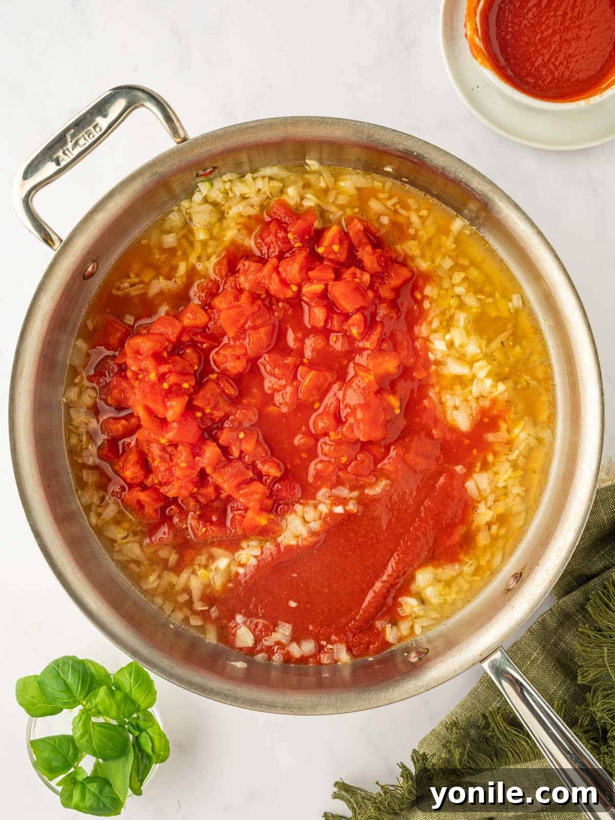 Prawn Pasta Perfection 7 Adding diced and pureed tomatoes to the sautéed aromatics in the skillet.