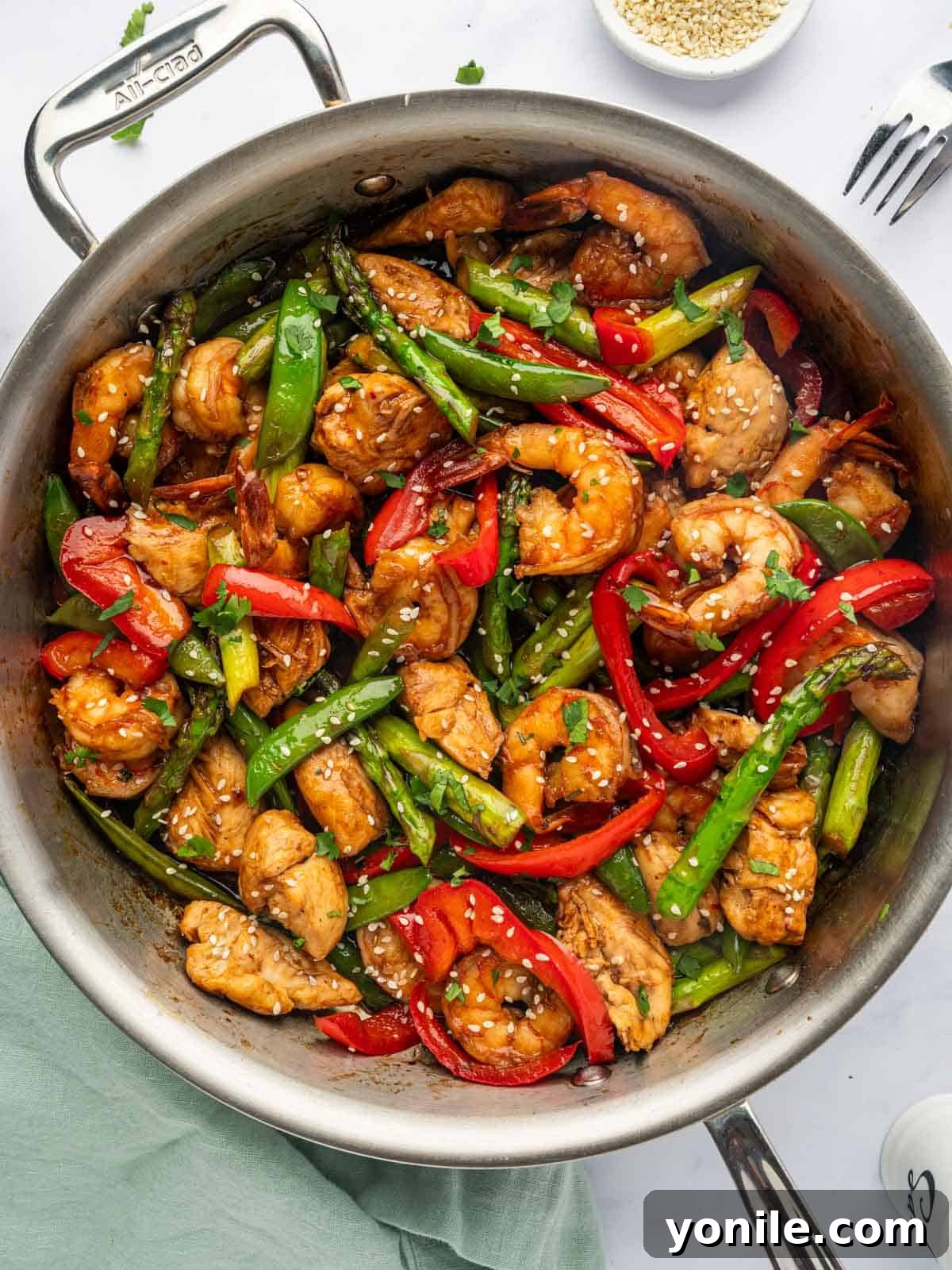 Sizzling Surf and Turf Stir-Fry 2 A vibrant Chicken and Shrimp Stir Fry cooking in a large skillet, showcasing tender chicken pieces, plump shrimp, and colorful vegetables like bell peppers and snow peas, glistening in a savory sauce.
