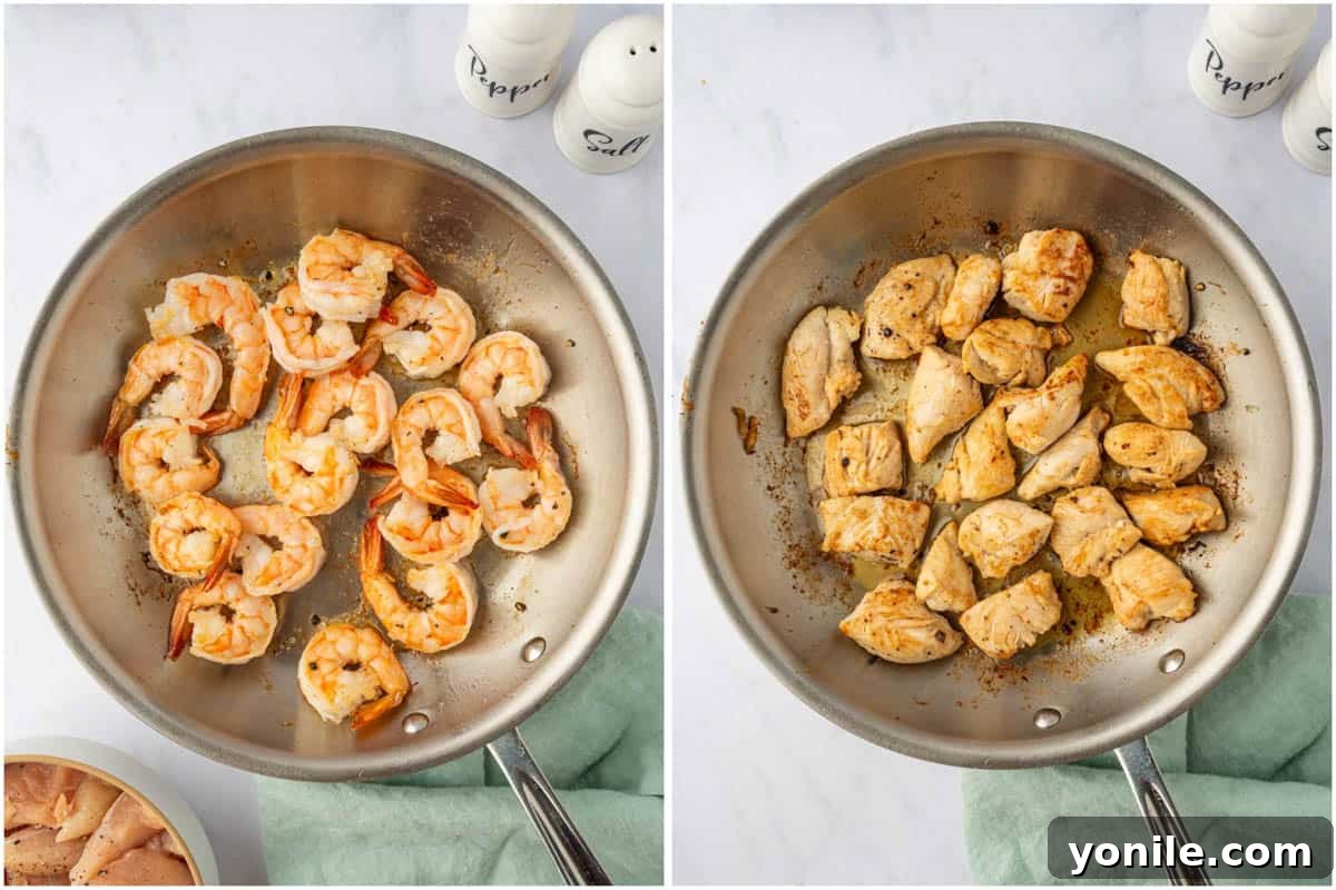 Sizzling Surf and Turf Stir-Fry 5 A large skillet on a stovetop, containing sautéing shrimp and chicken pieces, cooking separately to achieve ideal texture and doneness before combining with vegetables.
