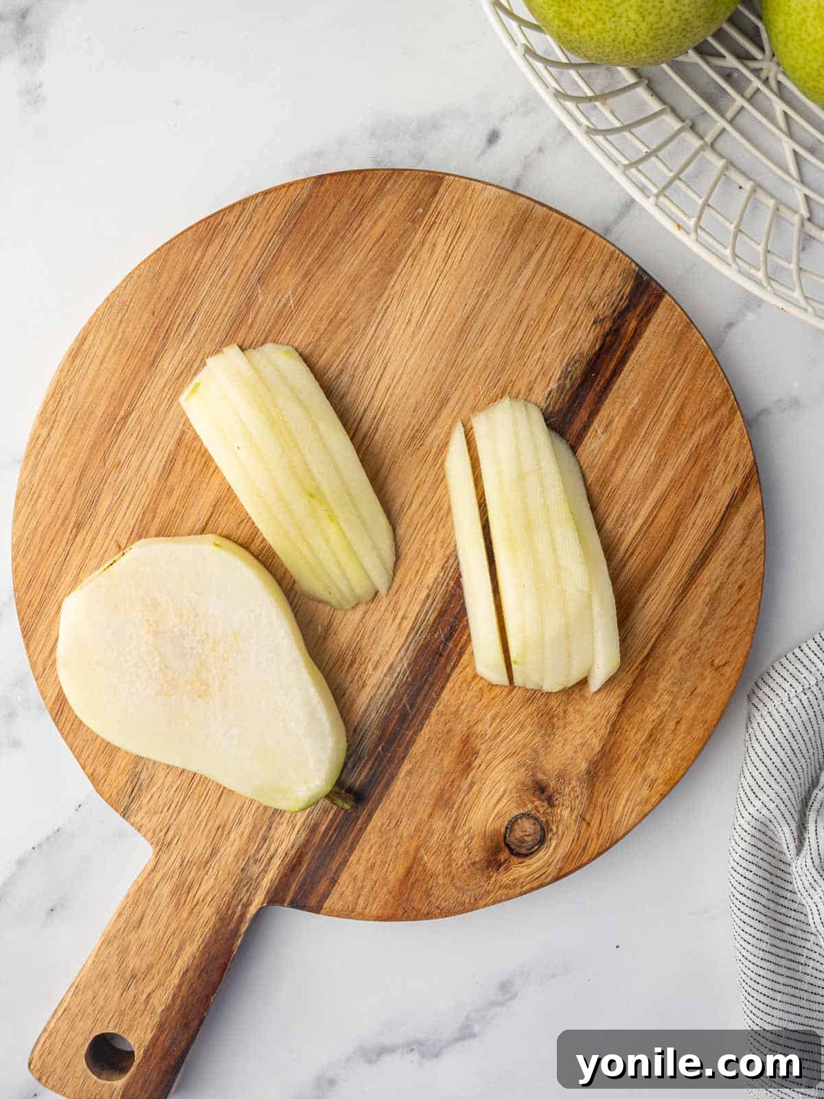 Thinly sliced pears on a cutting board, ready for baking.