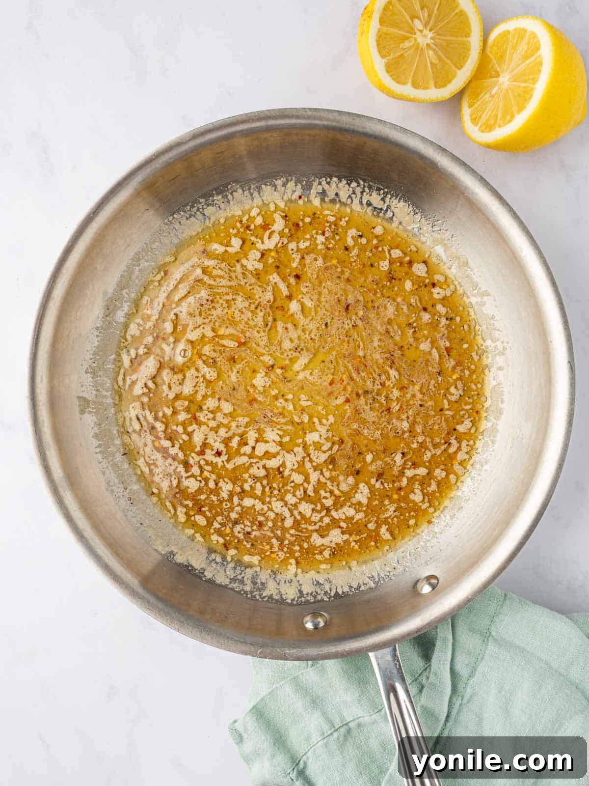 Zesty Lemon Pepper Chicken Tenders 8 Honey lemon butter sauce simmering in a skillet, ready for the fried chicken.