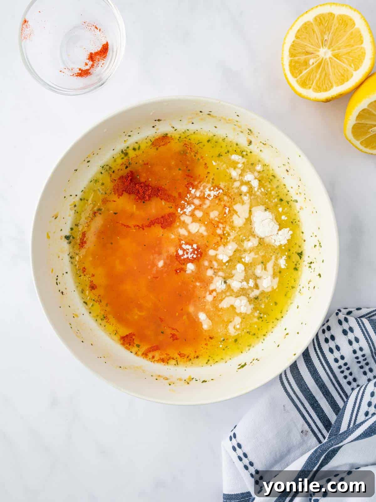 Preparing the lemon pepper marinade for chicken in a bowl.