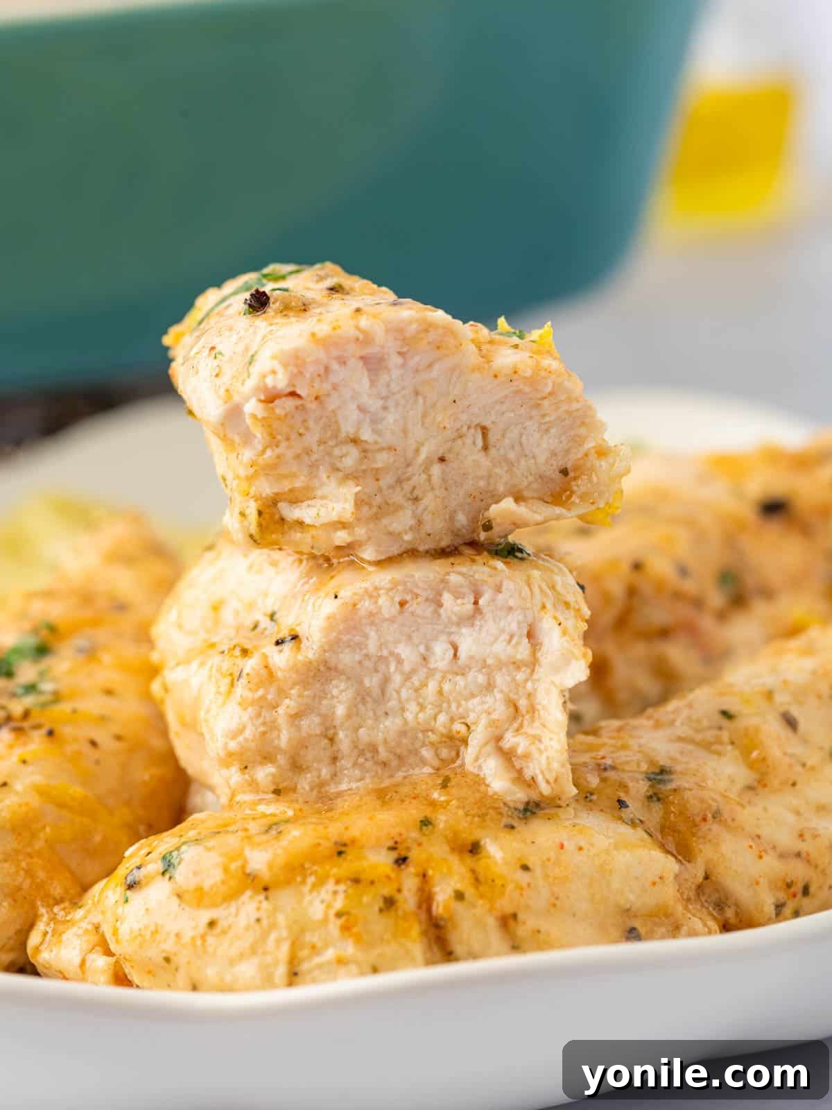 A juicy lemon pepper chicken tender is sliced in half, showing its tender interior.