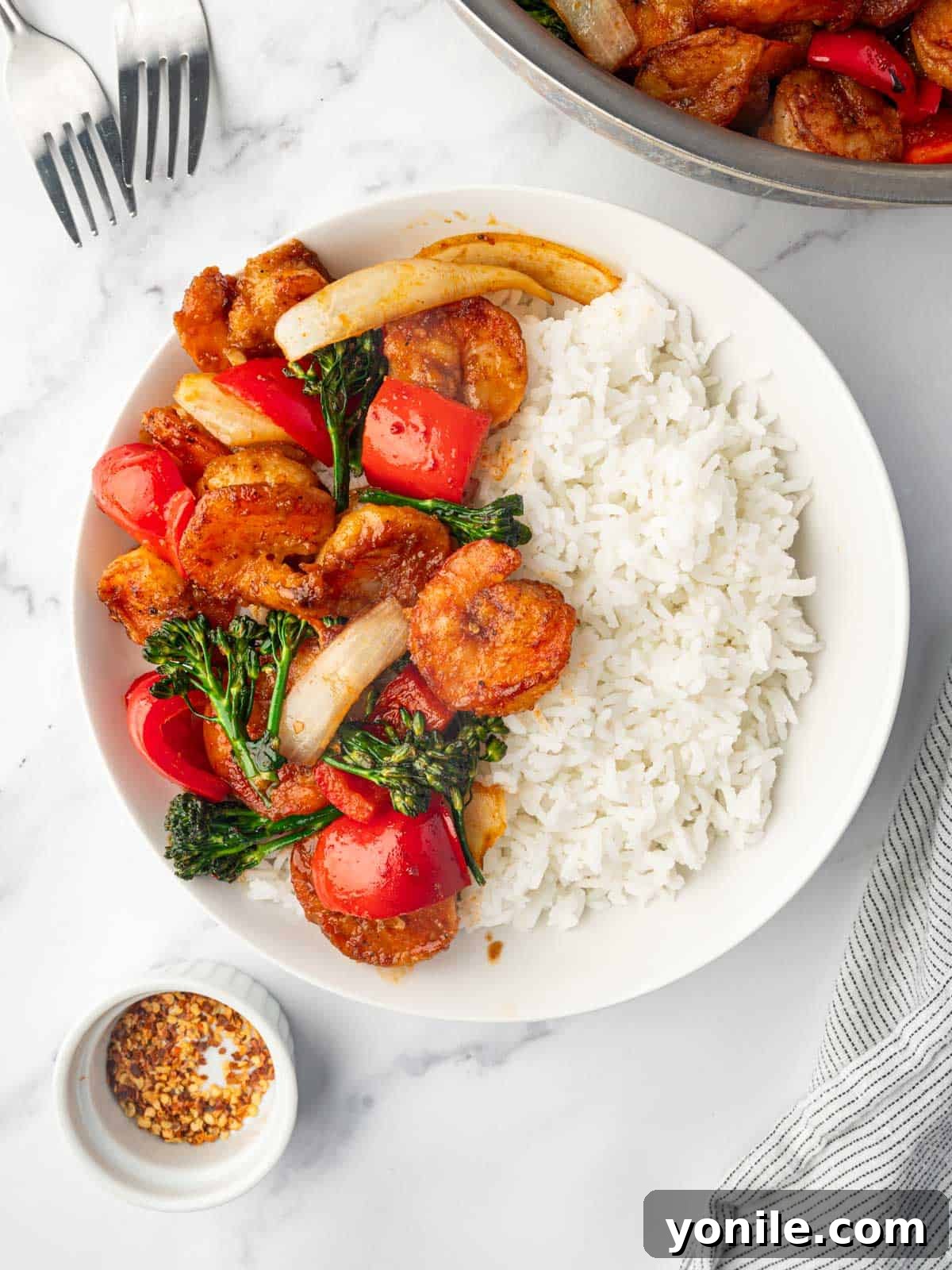 Panda Express Wok-Fired Sizzling Shrimp 11 A plate of homemade Panda Express Sizzling Shrimp served with steamed white rice, garnished with fresh herbs.