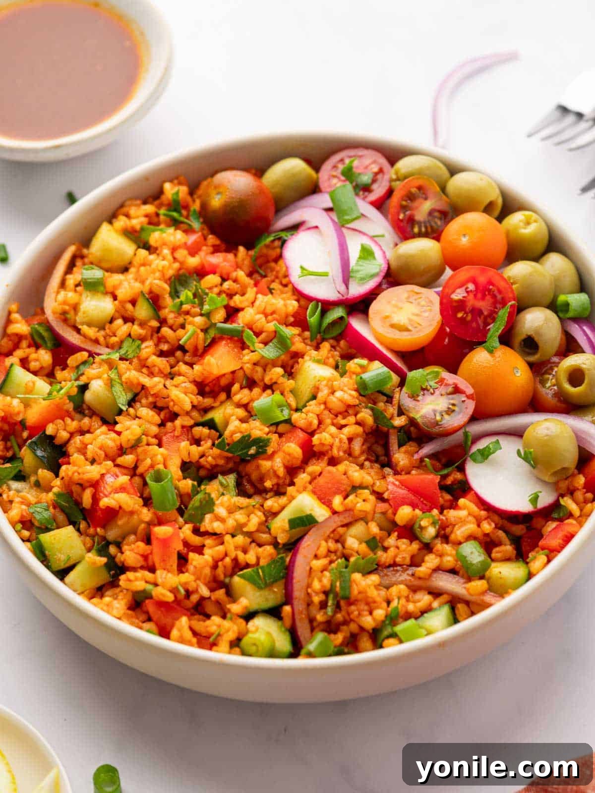 Vibrant Turkish Kisir Salad 12 A beautifully presented bowl of Turkish Kisir salad, garnished with a variety of fresh elements like cherry tomatoes, cucumber slices, and fresh herbs, ready for serving.
