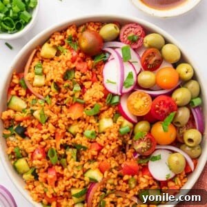A vibrant bowl of Turkish Kisir salad garnished with fresh tomatoes, olives, and radishes, emphasizing its fresh and appetizing appearance.