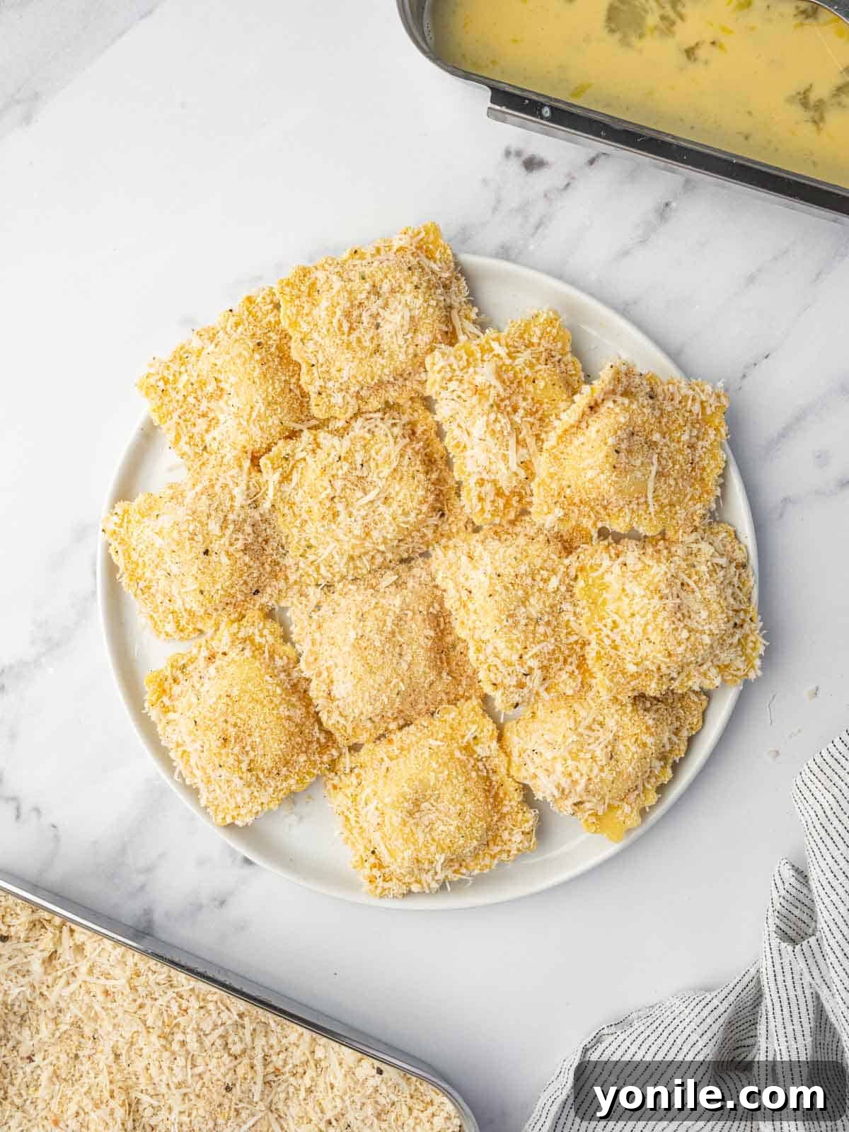 Crispy Air Fryer Ravioli 6 A platter of breaded ravioli prepared for air frying.