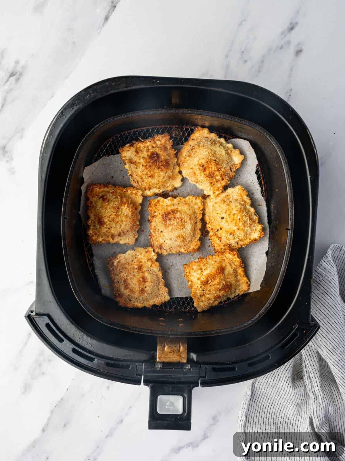 Crispy Air Fryer Ravioli 8 Air fryer basket with a single layer of air fried ravioli.