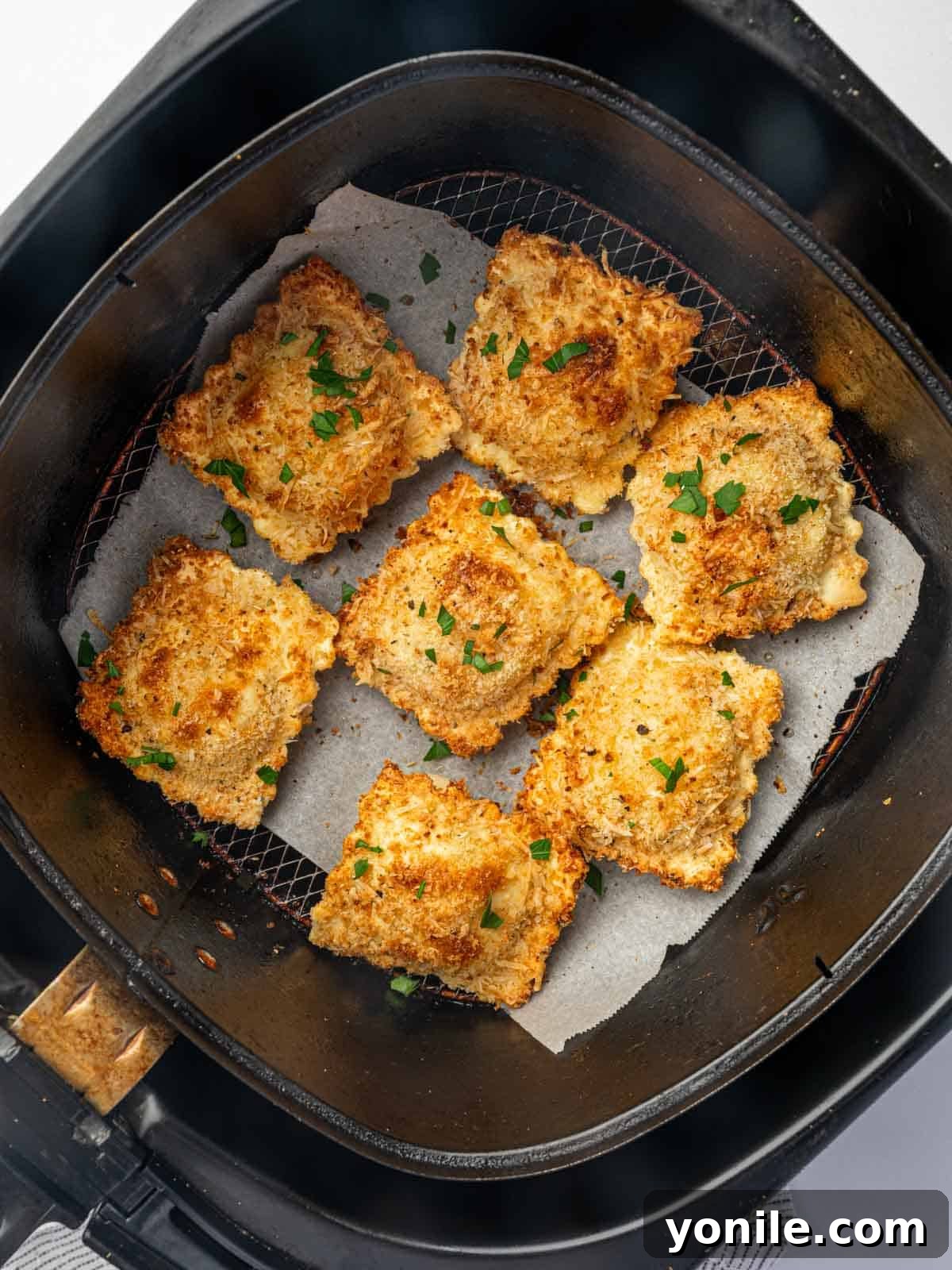 Crispy Air Fryer Ravioli 9 Air fried ravioli in an air fryer basket.