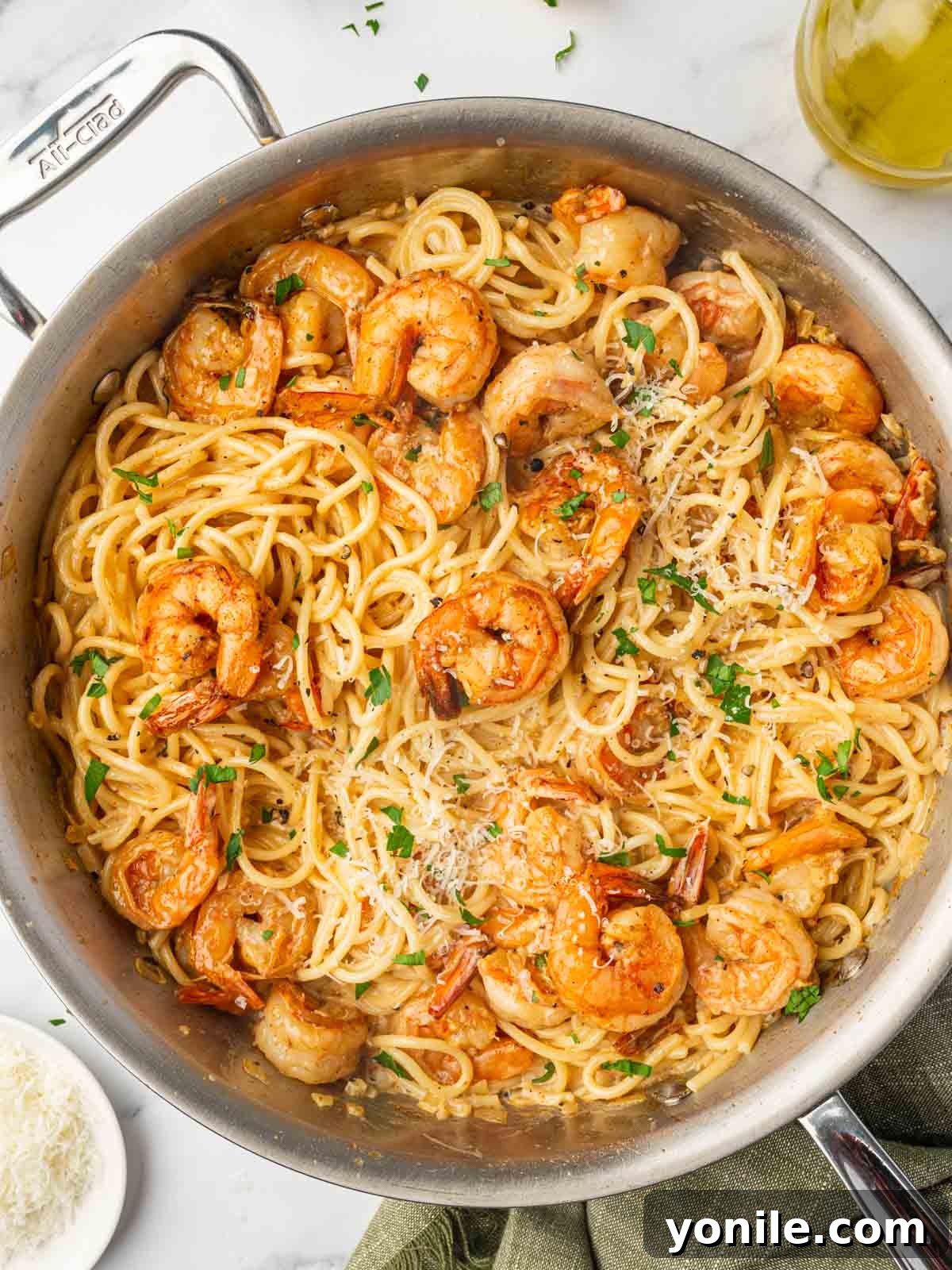 Fiery Cajun Shrimp Scampi with Linguine 2 A skillet with spaghetti and spicy shrimp, garnished with fresh parsley.