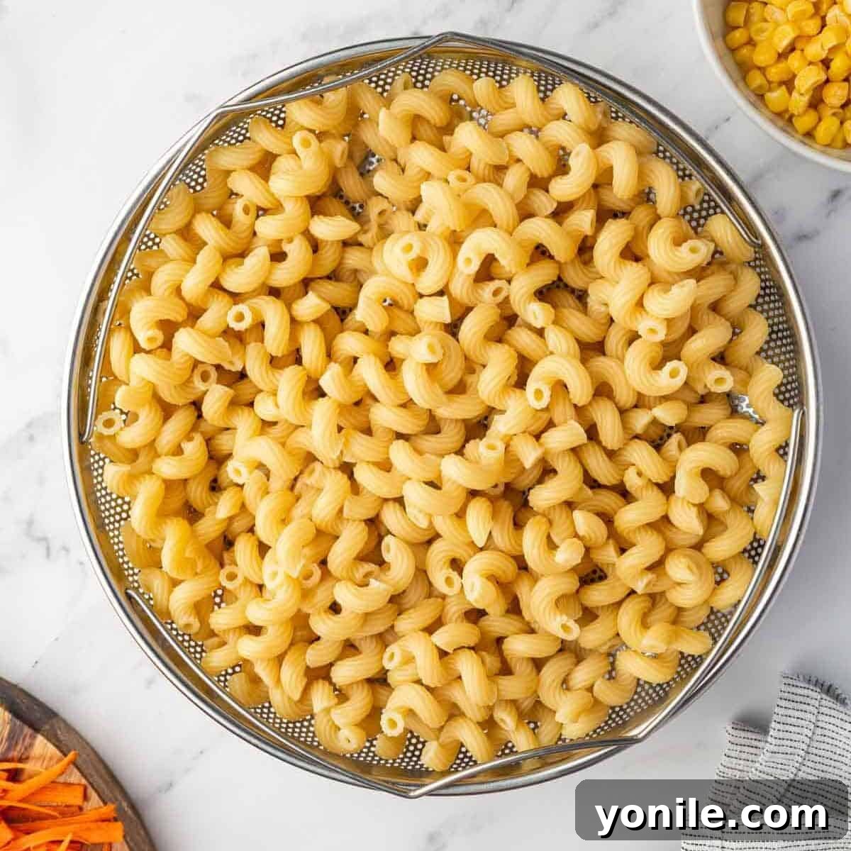 Cooked pasta is drained in a colander, ready to be added to the sauce.