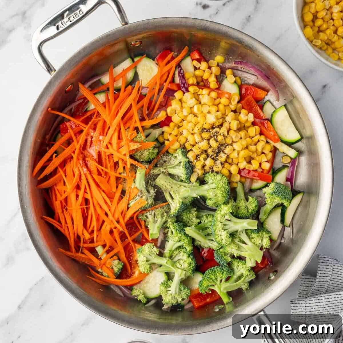 All the veggies are cooking in a skillet, becoming tender.