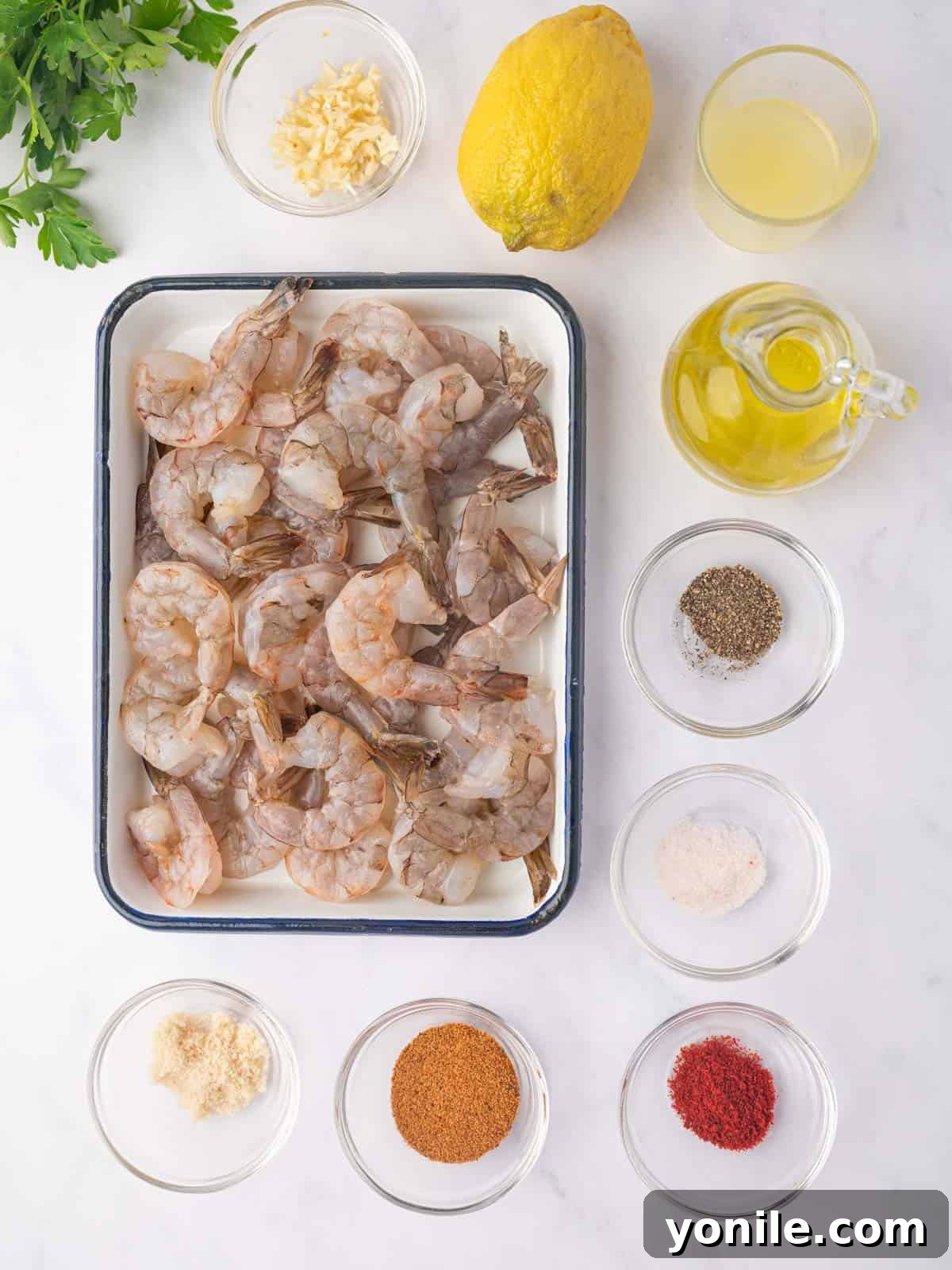 Fresh ingredients laid out for making Cajun shrimp, including shrimp, olive oil, lemon, and a spice blend.