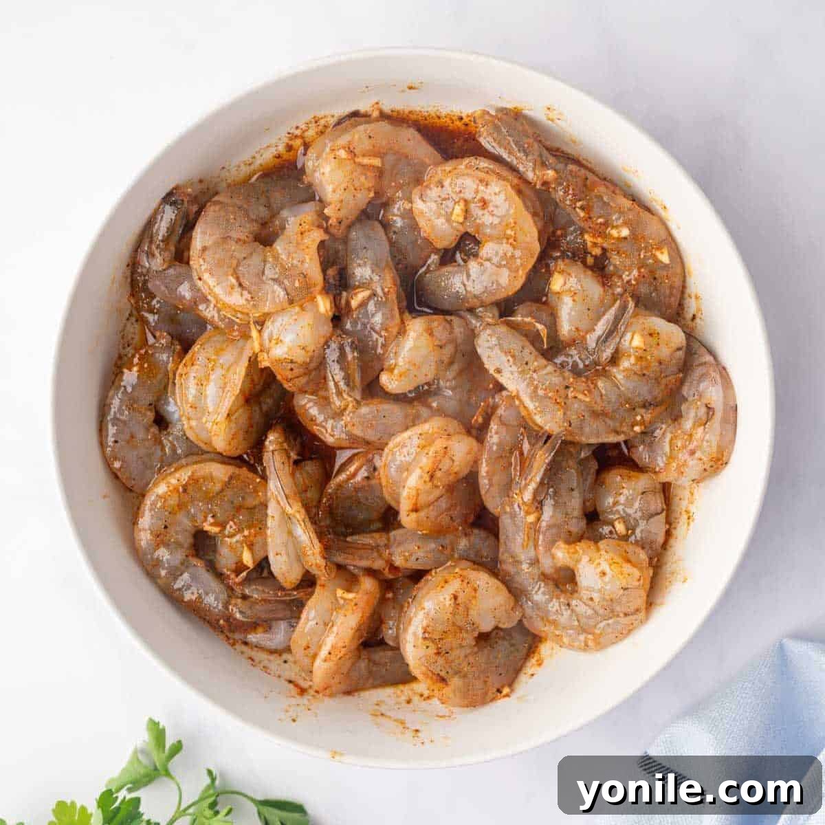 Shrimp being tossed in cajun seasonings, ready for marination.