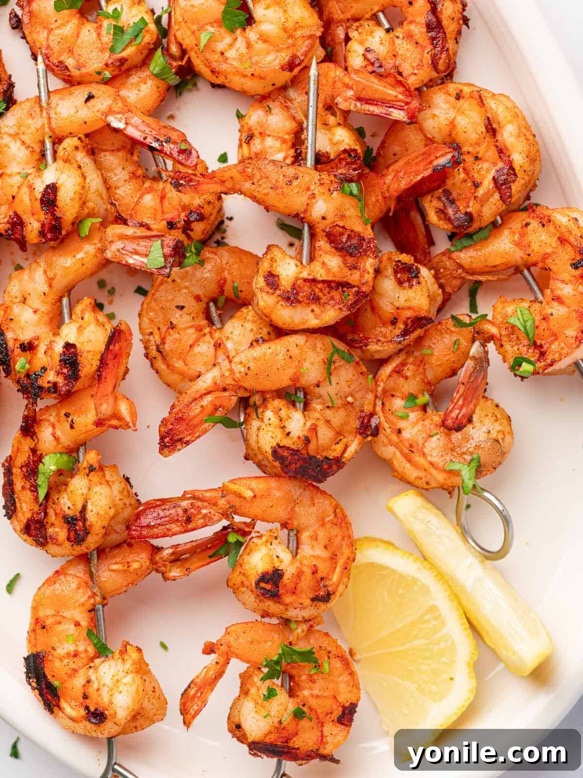A generous pile of grilled Cajun shrimp skewers, garnished with fresh herbs, on a rustic platter.
