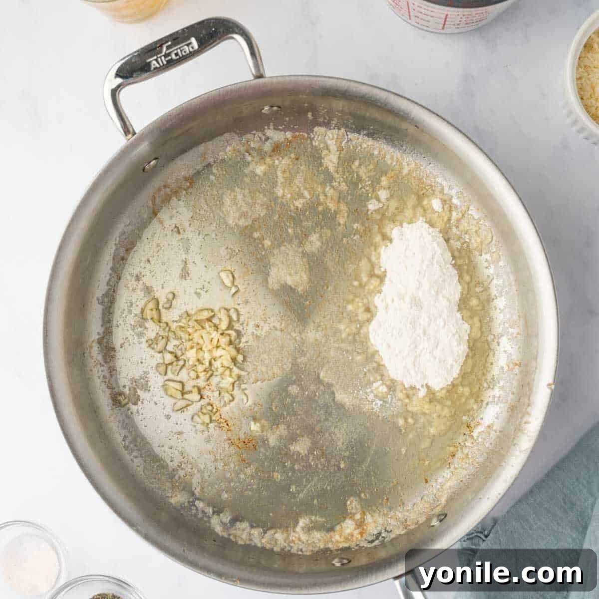 Creamy Cheese Tortellini Alfredo 5 Fresh garlic being gently sautéed in melted butter in a skillet, creating an aromatic base.