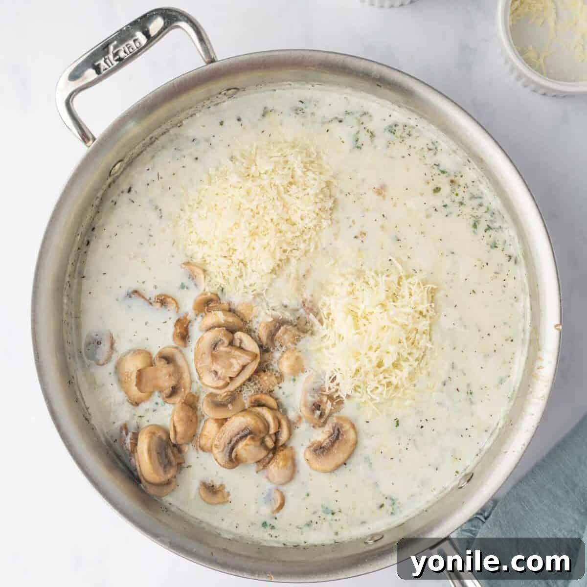 Creamy Cheese Tortellini Alfredo 7 A rich, creamy Alfredo sauce, combined with sautéed mushrooms and grated cheese, simmering gently in a skillet.