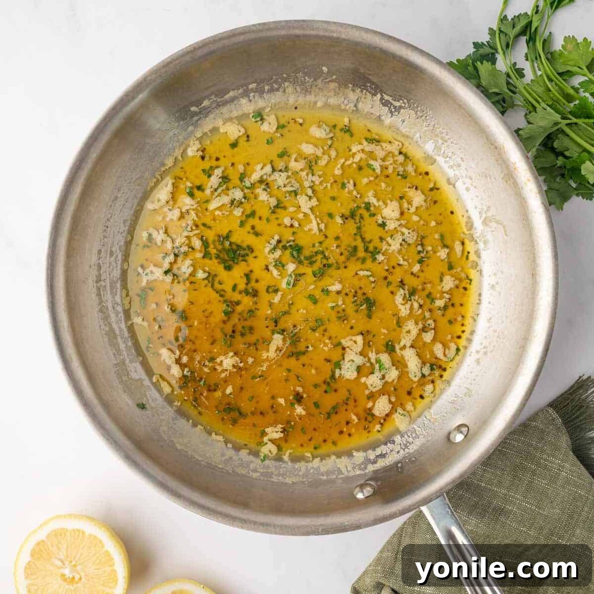 Honey lemon pepper sauce simmering gently in a small skillet.