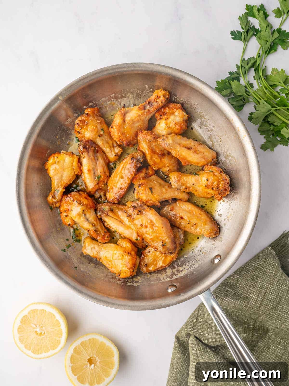 Honey Lemon Pepper Wings coated in sauce in a skillet, ready to be served.