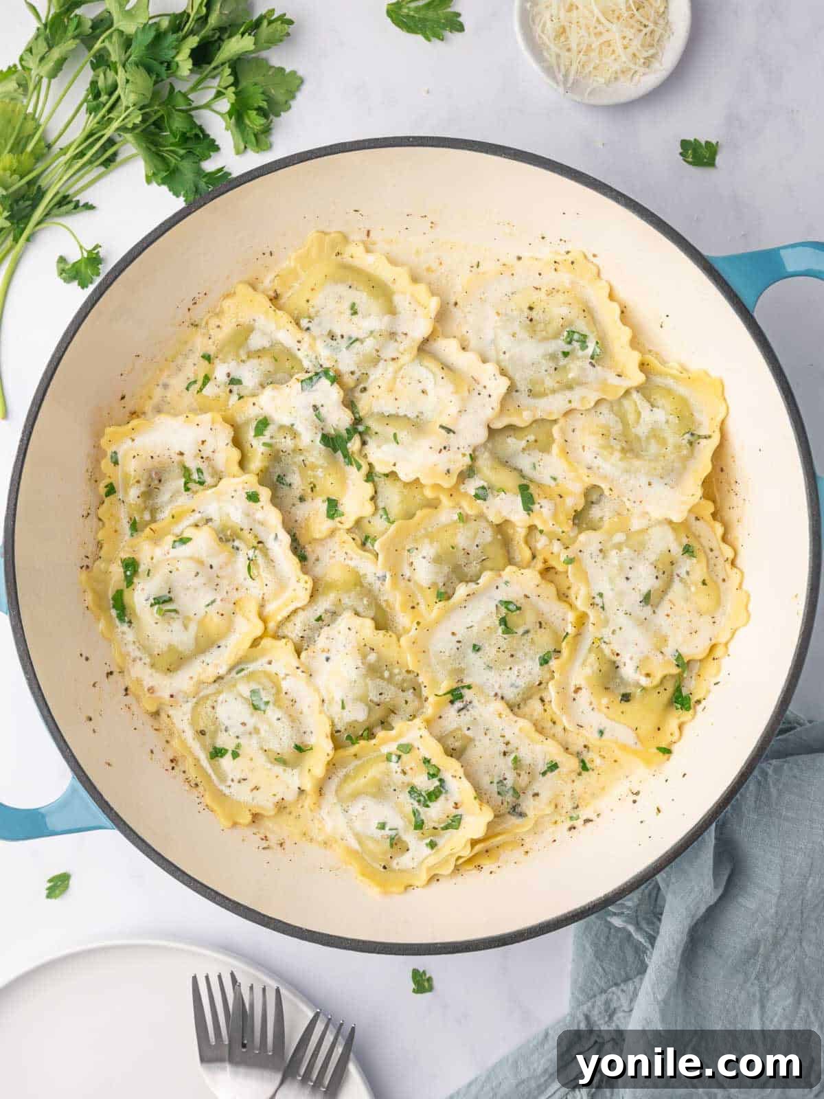 Spinach and ricotta ravioli with cream sauce in a dutch oven.