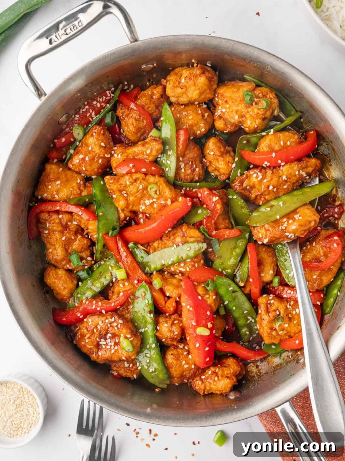 Chicken is combined with vegetable and sauce is a skillet.